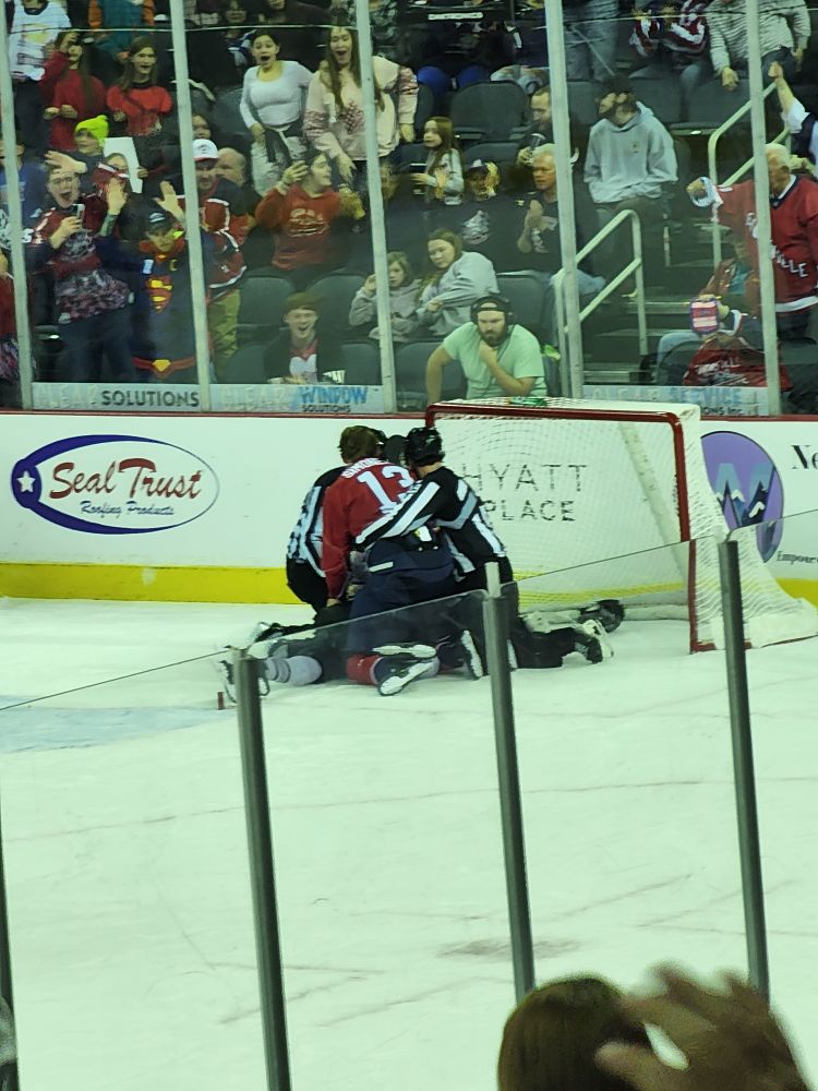 Evansville Thunderbolts player Simoneau fighting a Quad City Storm player after knocking the net off the mooring. The officials are pulling them apart after they hit the ice near the crease