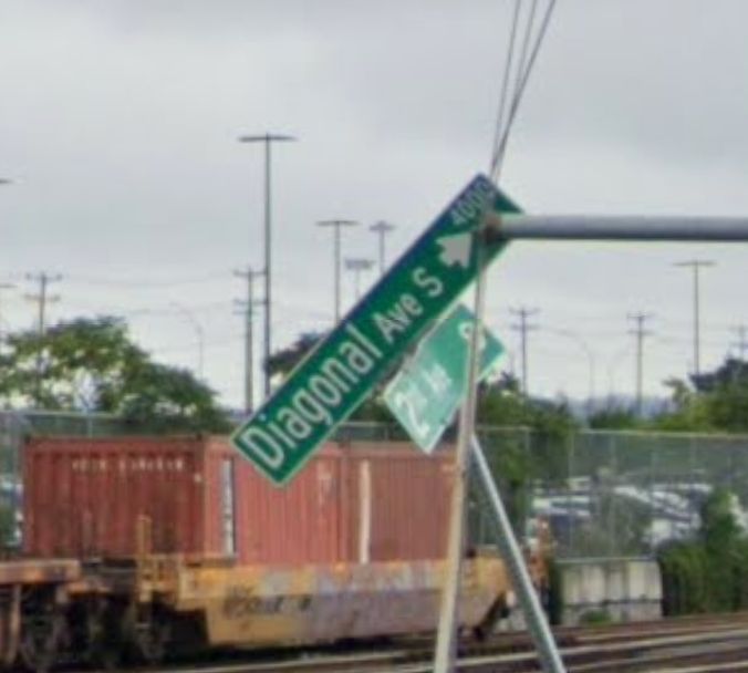 Google Street View screenshot of a sign for Diagonal Avenue South sitting askew on a leaning pole, the sign itself appearing diagonal from the camera's point of view