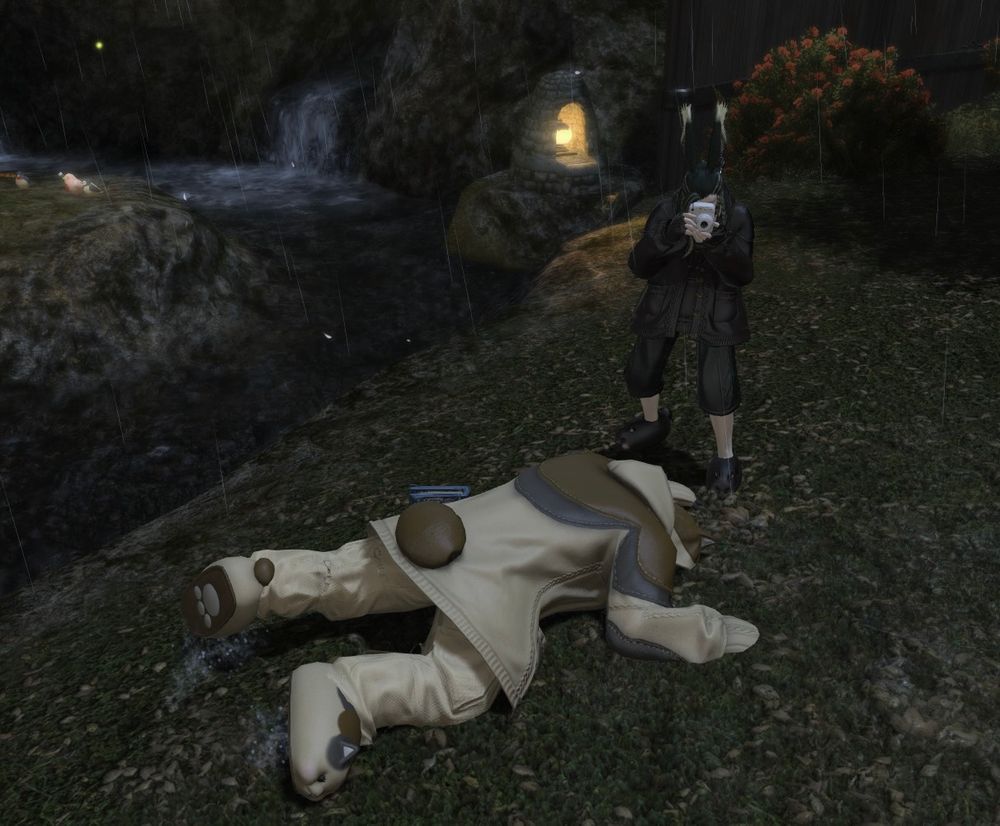 A hrothgar (me) in cat pajamas plays dead on the ground of rainy Gridania. A viera (Ghost), also in cat pajamas, squats down to take a polaroid picture of my dead body. 