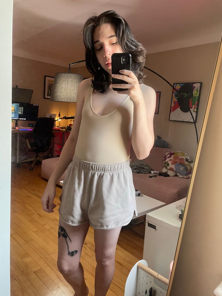 a white woman in a bodysuit, shorts 