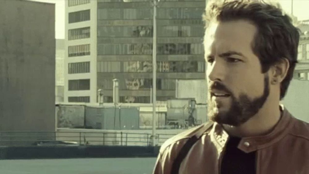 a man with a beard is standing in front of a building