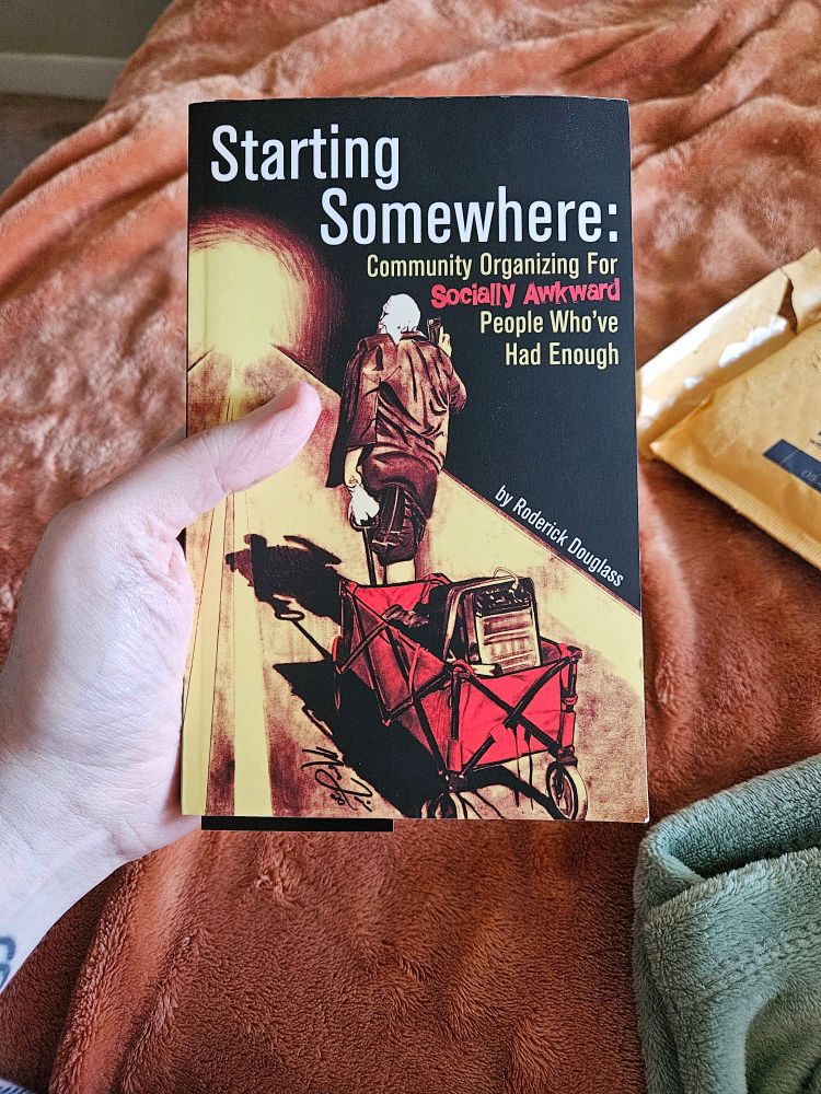 Photo of the cover of _Starting Somewhere: Community organizing for /socially awkward/ people who've had enough_ by Roderick Douglass