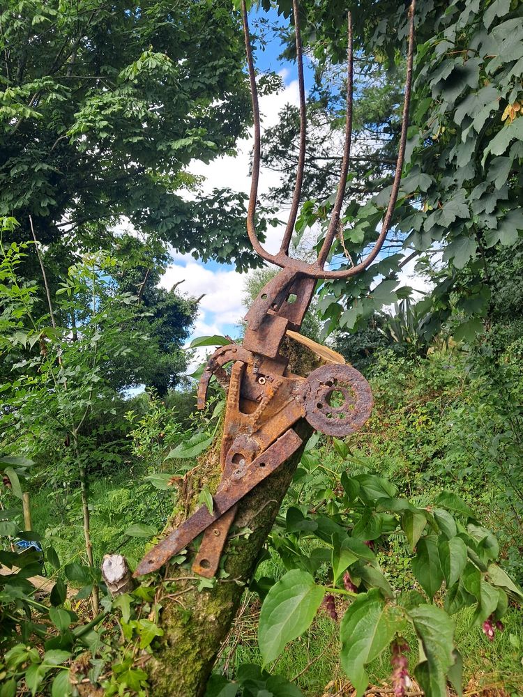 Metal sculpture  on old apple tree in garden.