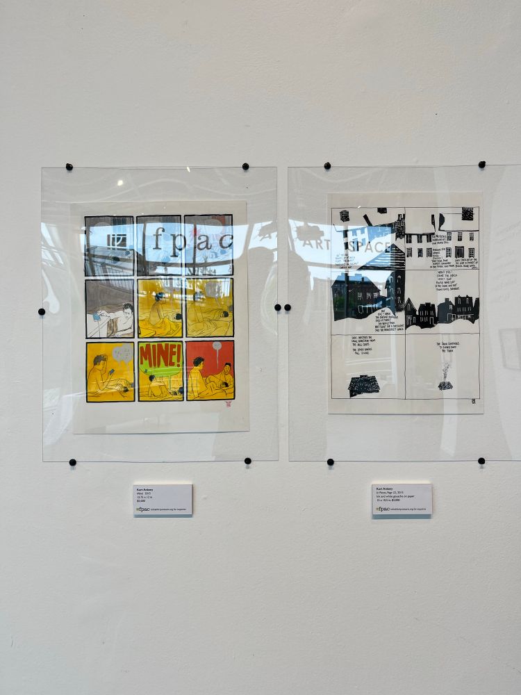 Framed original comics pages on a gallery wall. 