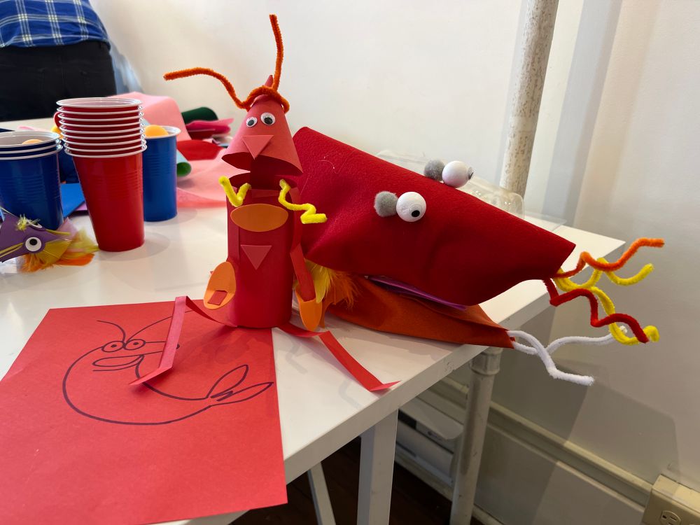 Photograph of a concept sketch, paper prototype, and monster hand puppet