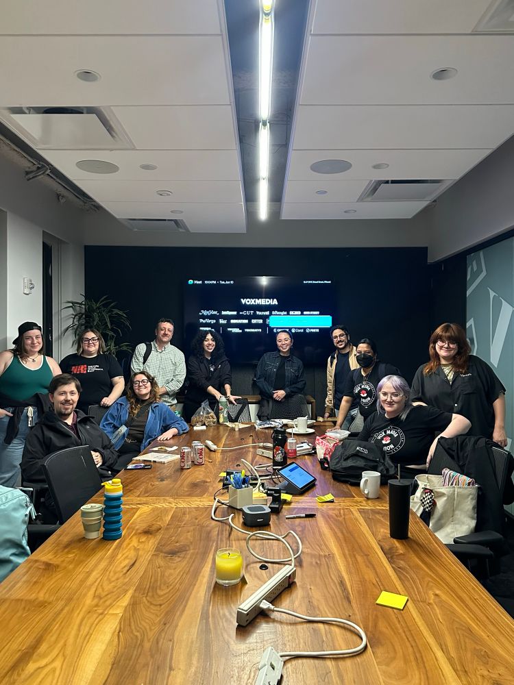 People standing around a conference table room. 