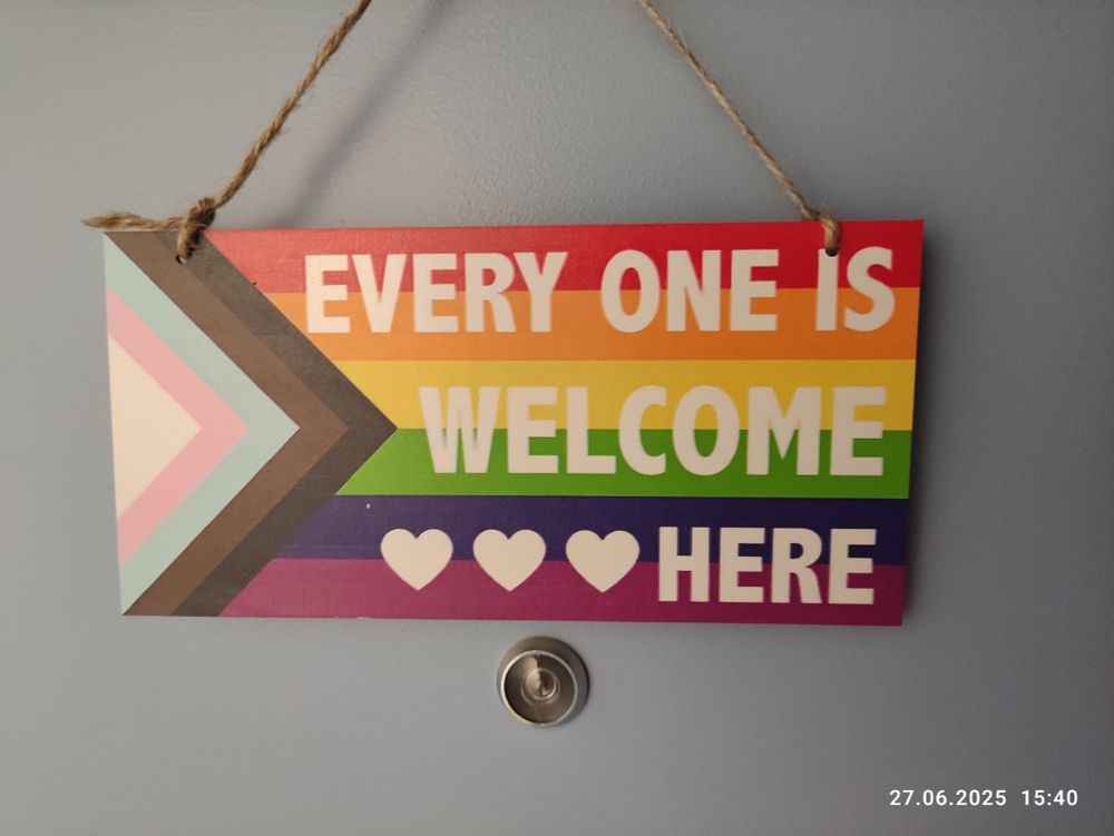 Ein Türschild in LGBTQ-Optik mit dem Satz"Everyone is welcome here"