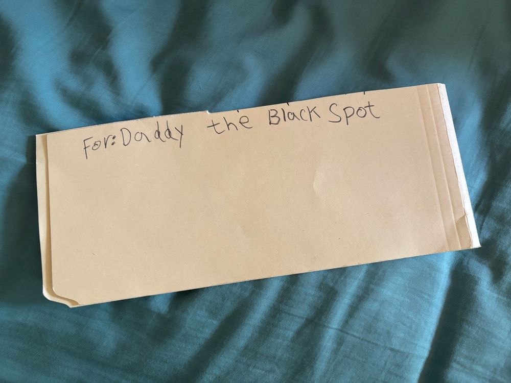 On the reverse of the paper, there is text: “For Daddy: The Black Spot”