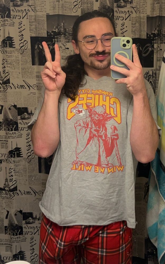 me in a star wars chiefs shirt that has yoda on it saying “win we will” i’m wearing christmassy red and green pj bottoms