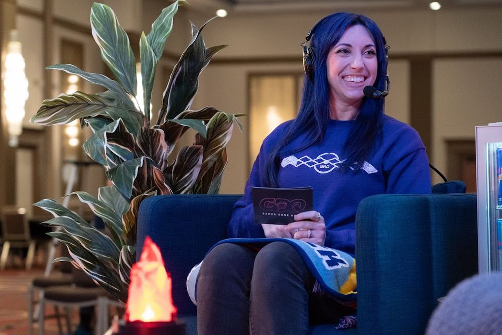 Jaidlyn sitting in a chair with a headset microphone in front of a small fake fire