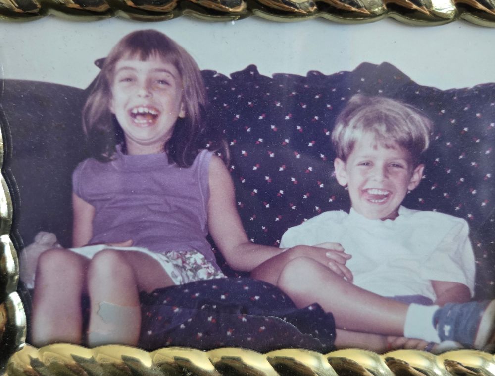 Two kids laughing on a couch