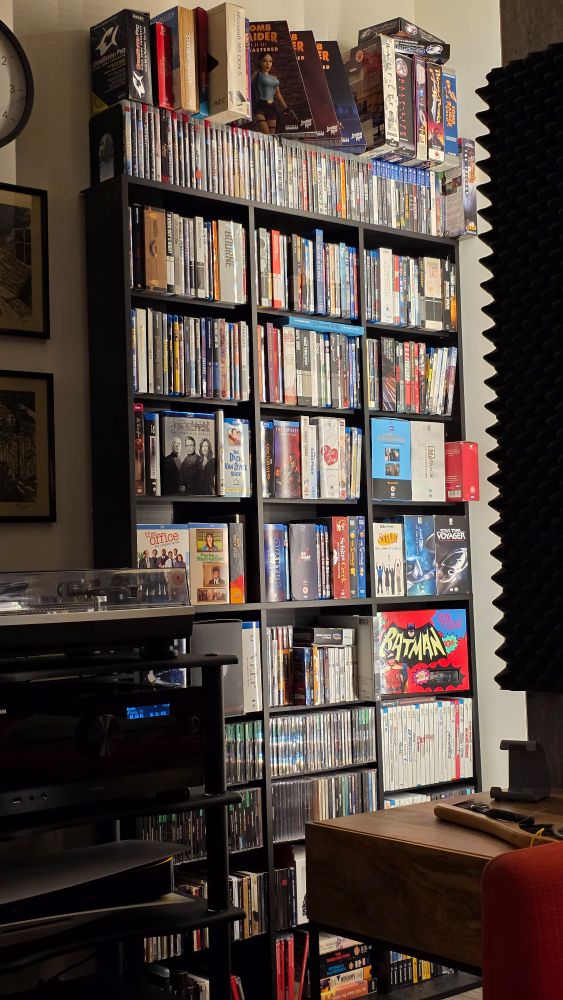 A tall shelf with lots of Blu-ray disc cases and video game boxes
