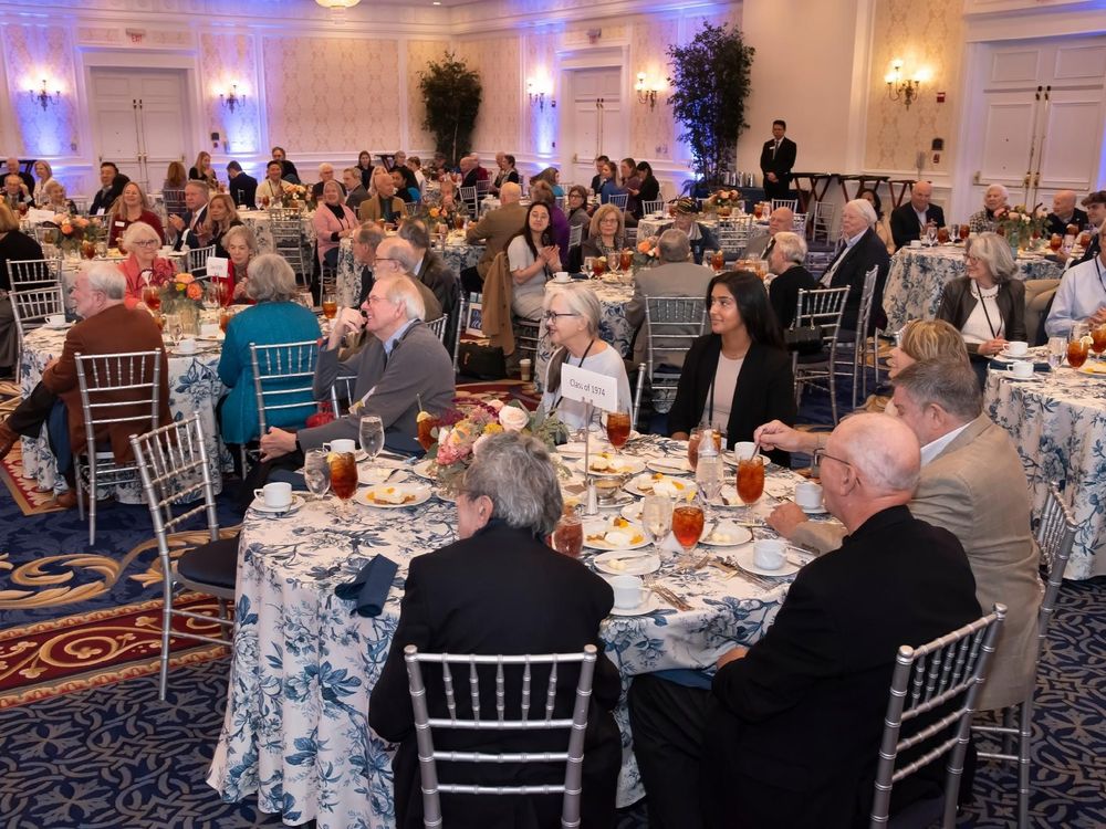 Attendees seated at round tables during a formal event in an elegantly decorated banquet hall.
