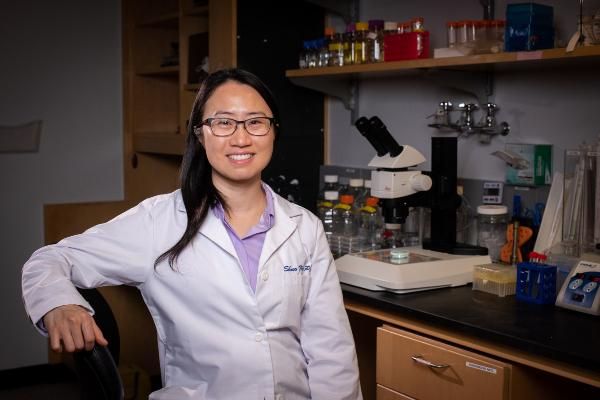 a person in a lab coat sitting in a lab