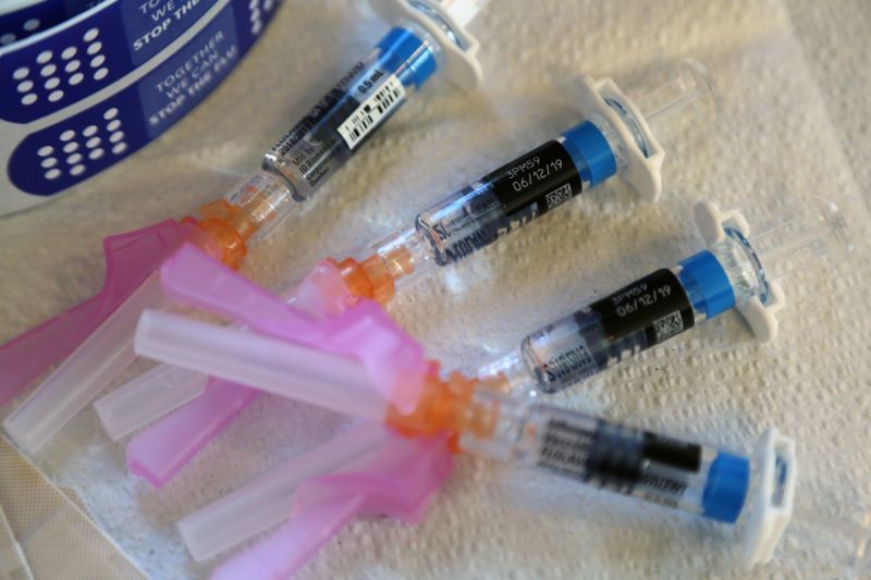 Several syringes, arranged on a white surface.