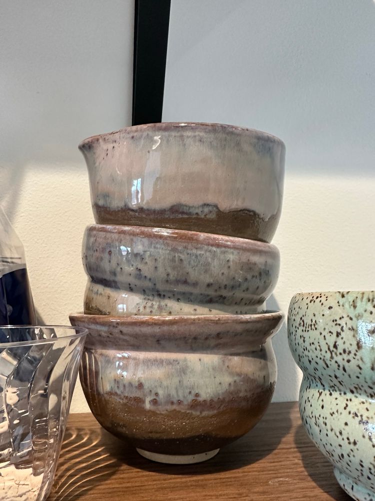 Stack of various matcha tea bowls with floating white and purple glaze