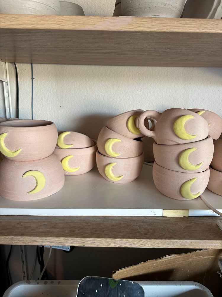 Shelf of bisque moon mugs and bowls. Work in progress