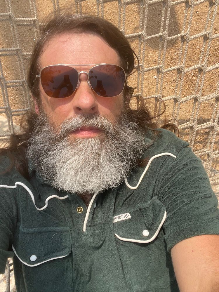 Aarik in sunglasses on a hammock looking unbothered 