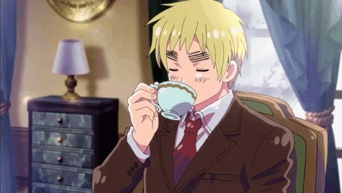 a man in a suit and tie is drinking from a teacup