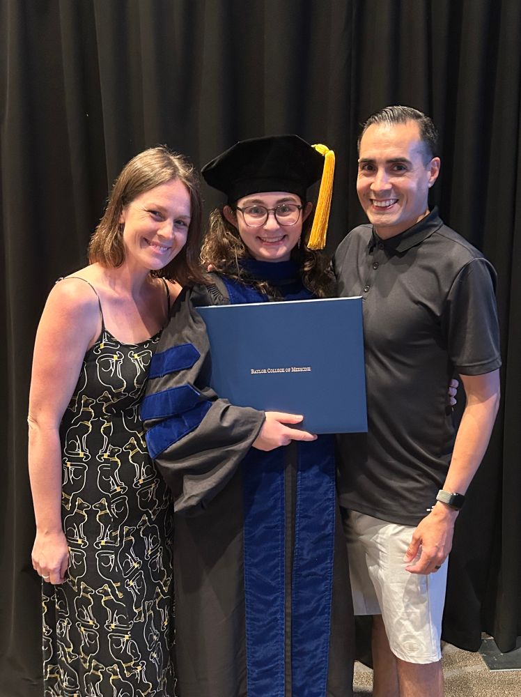 A picture of my sister (left), myself in PhD regalia and diploma (middle), and my brother in law (right). 