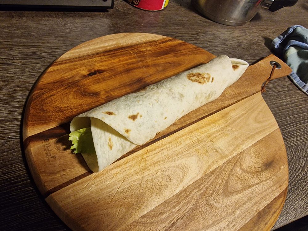 Zusammengerollter Dürüm auf einer Holzplatte