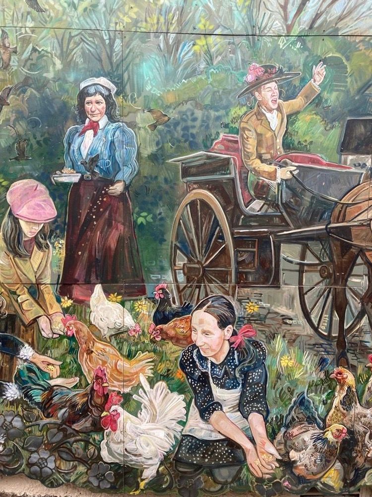 A mural depicting scenes from Victorian Colinton, featuring young women feeding chickens.
