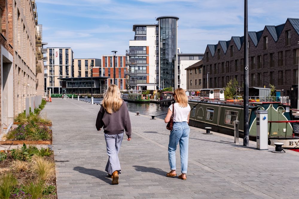 Two young women walking along the newly redeveloped canal towpath in Fountainbridge, Edinburgh.