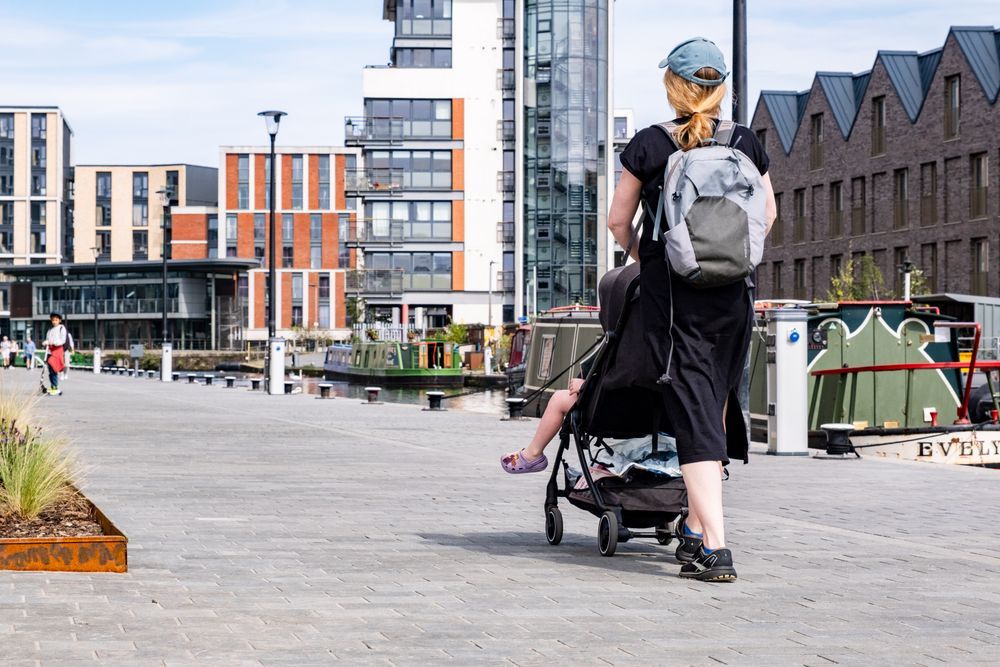 A woman pushing a buggy on the new canal towpath in West Edinburgh. A child on a scooter is in the background.