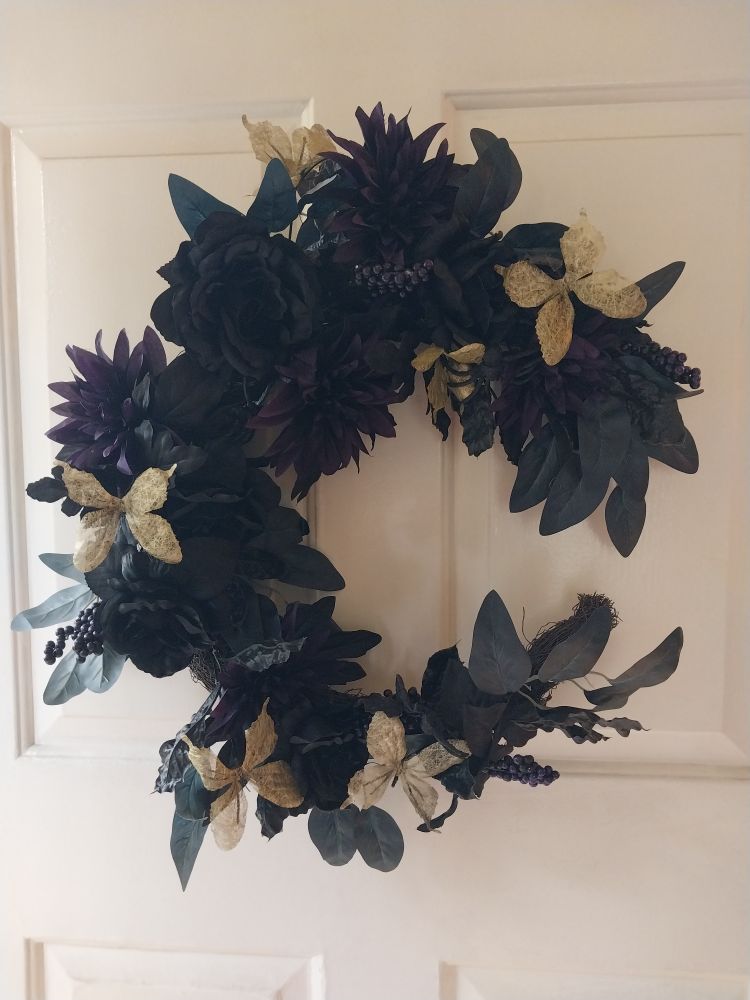 Halloween wreath with black roses, dark dahlias, and golden butterflies.