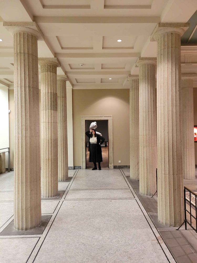 Juliette poses in a doorway at the end of a colonnade