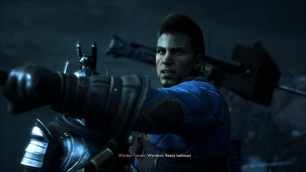A screenshot of Warden Tomasz pointing off screen to the left with a ballista behind him, shouting "Wardens! Ready ballistas!"