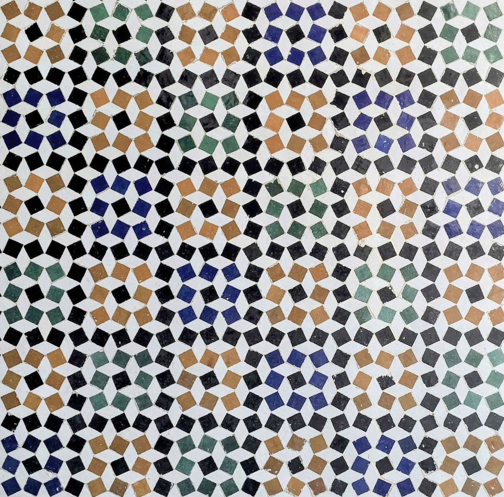 Tiling of tilted squares in black, yellow, blue and grey. The empty spaces, with shape of horizontally and vertically oriented rhombuses, are reminiscent of the orthorhombic structure of CsPbBr3 perovskite.