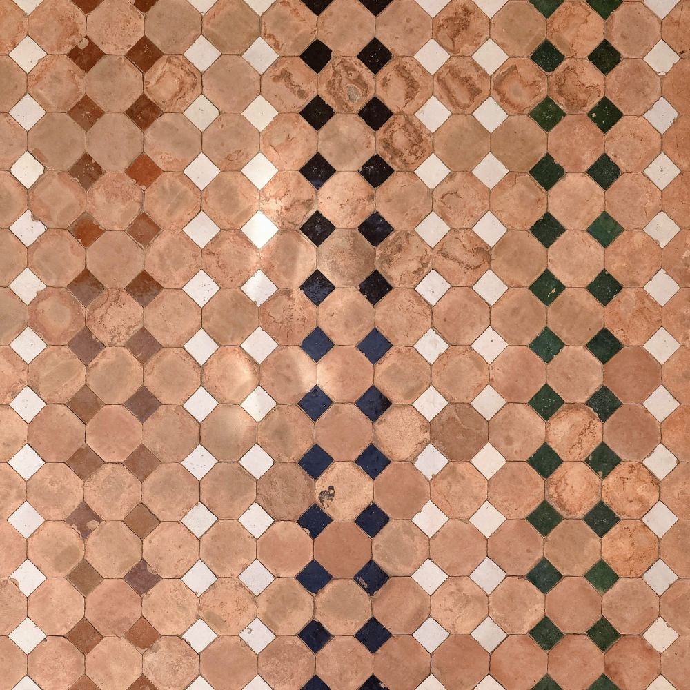 An square grid of coloured square tiles spaced by octagonal terracotta-colour ones. The colour of the square tiles is homogeneous vertically, but changes every two rows, from left to right (brown, brown, white, white, blue, blue, white, white, green, green, white...)