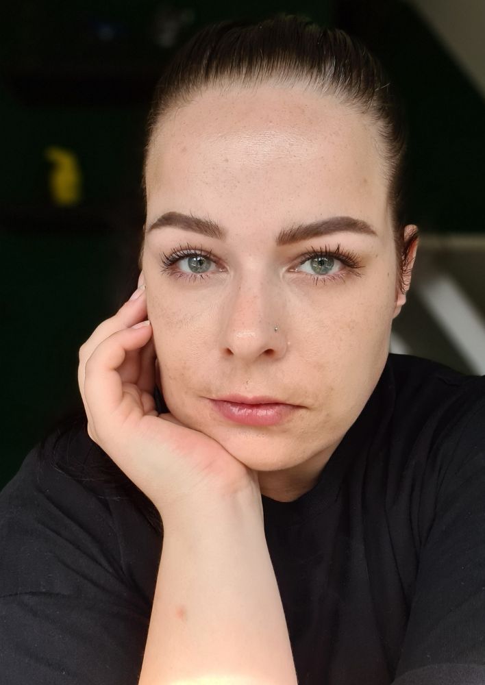 mel met een zwaar hoofd want ze leunt haar kin op haar hand. 