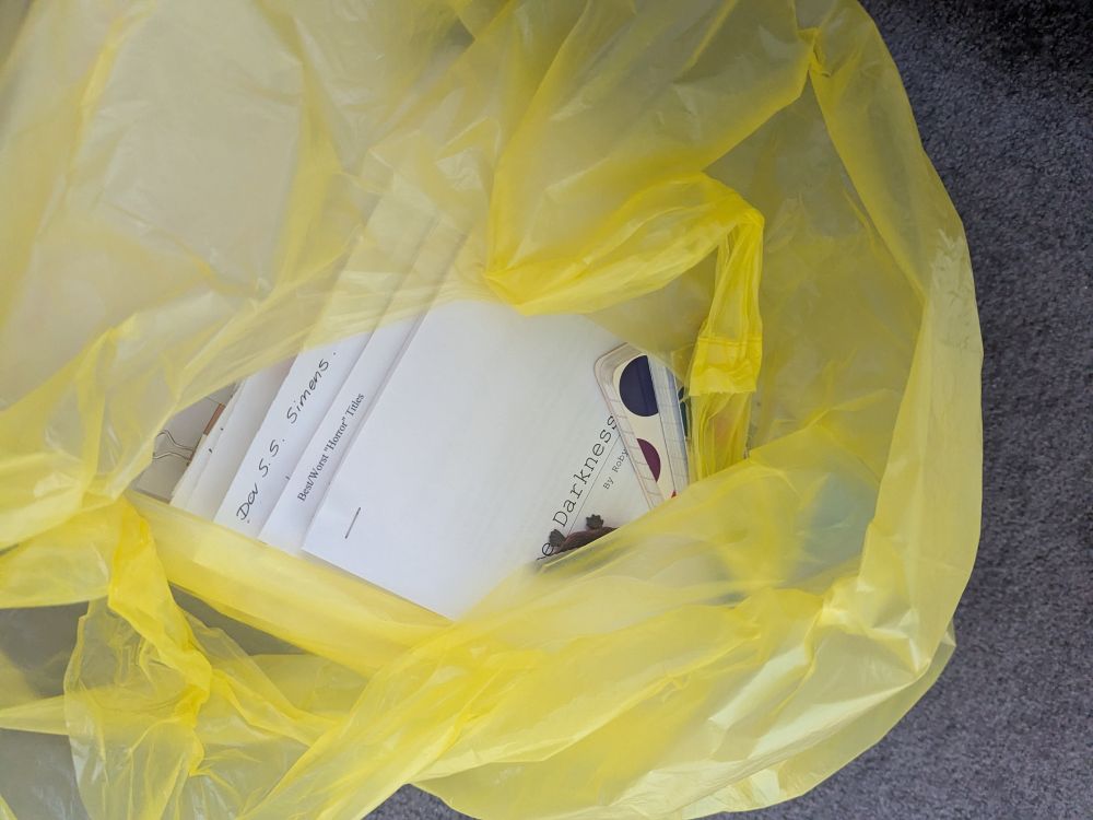 Old manuscripts and book/film notes in a yellow bin bag