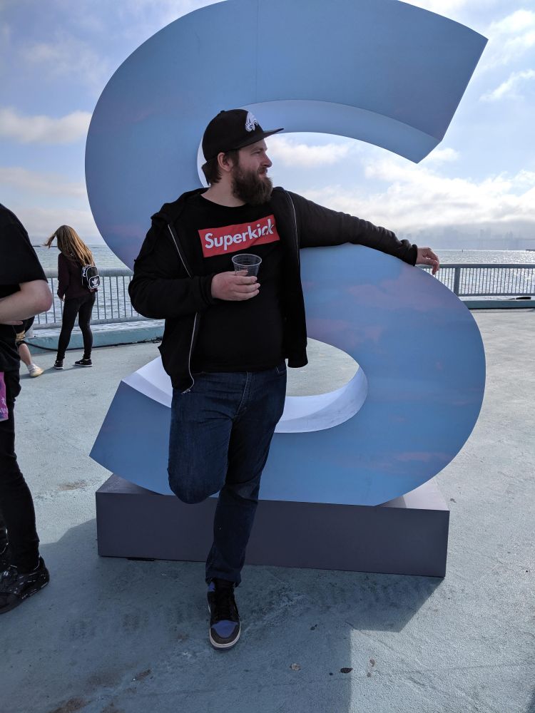 Patrick standing in front of a big S at the Porter Robinson festival a few years ago, wearing a superkick tshirt made to mimic the supreme box logo and he looks really handsome