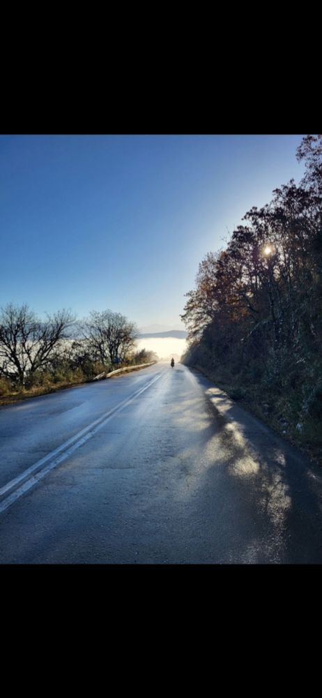 Cycliste roulant au loin vers la brume