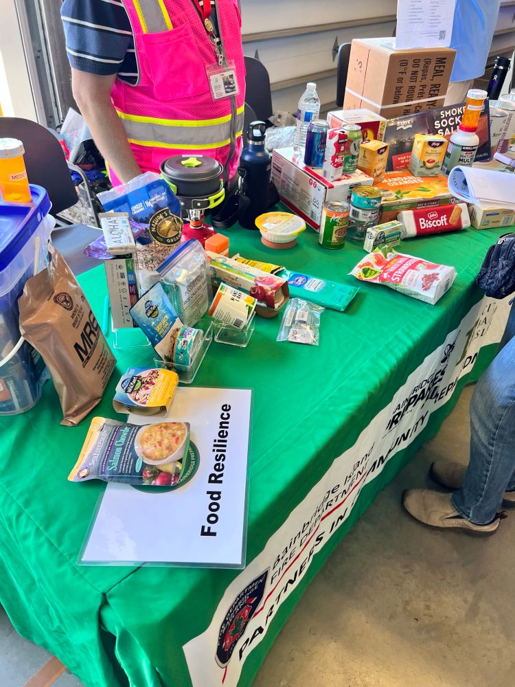 Various kinds of pre-packaged emergency food on display at the Food Resilience table.