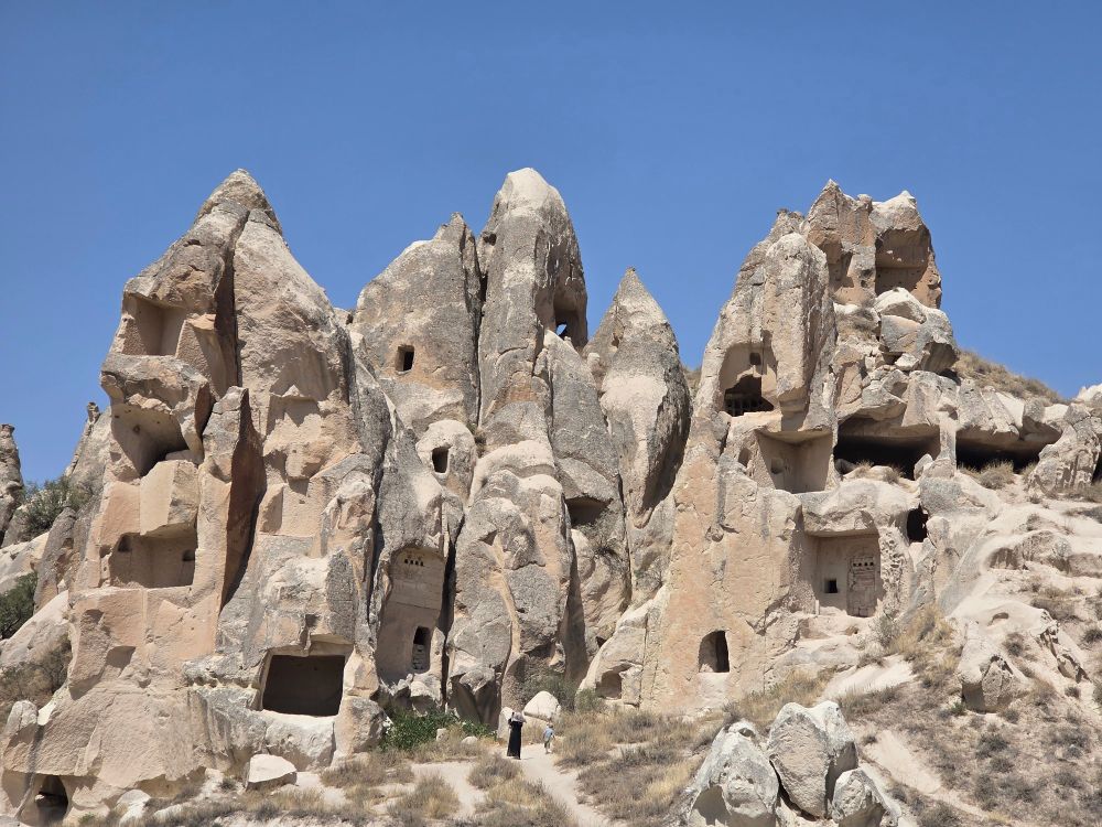 A series of fairy chimneys, with windows and doors cut into them. 