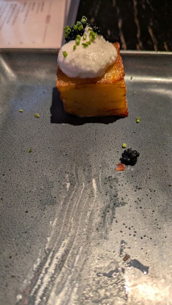 Thousand layer crispy potato with vegan sour cream, chives, and vegan caviar