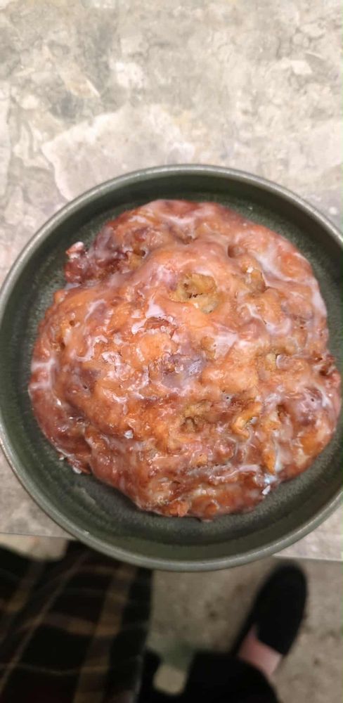 An apple fritter on a small plate