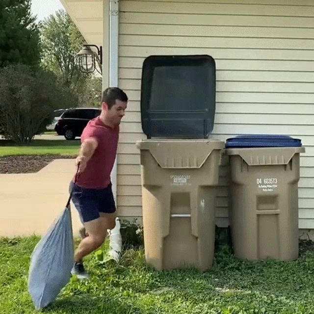 a man is carrying a bag in front of a garbage can that says 04 60573