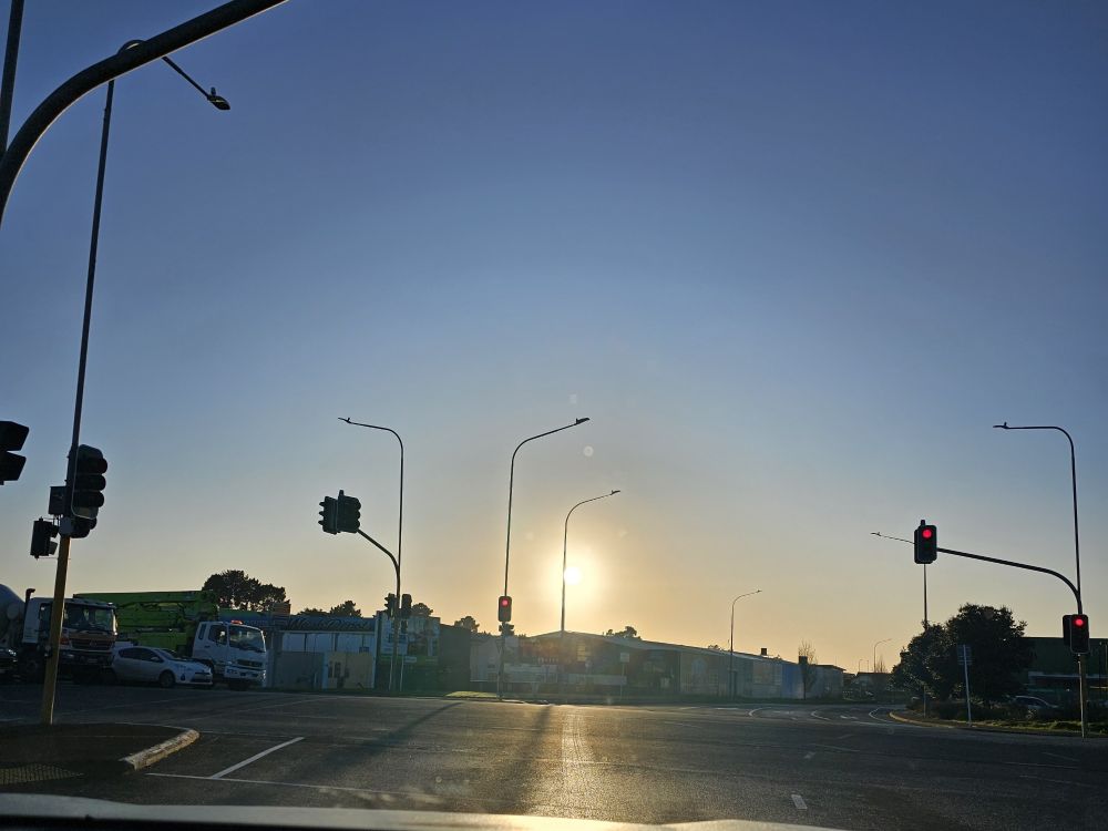 Sun rising at traffic lights