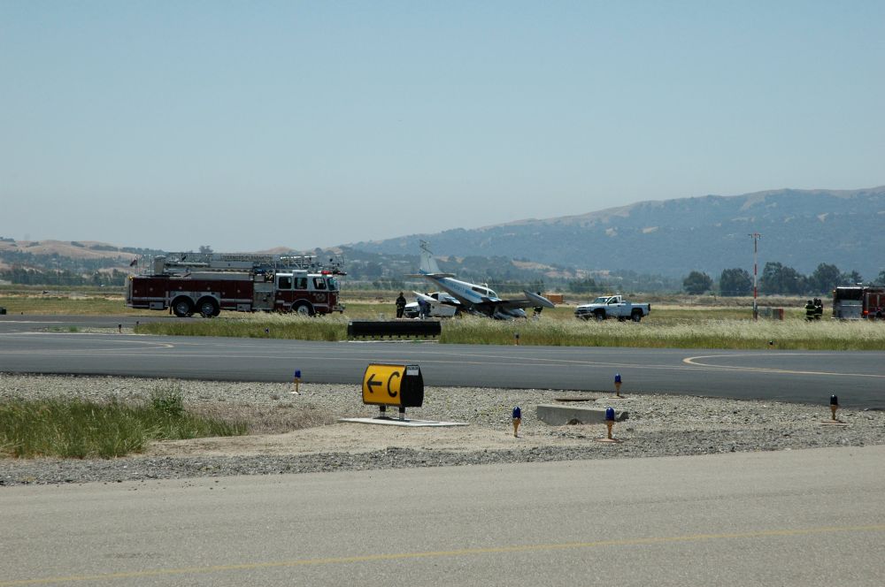 A Cessna 310N twin-engine airplane that is nose down after crash landing with a front gear that wouldn't lock down.