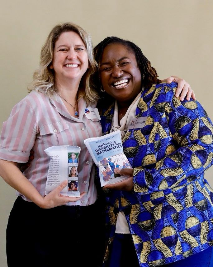 Two women, a beautiful black woman smiling wearing a blue and gold jacked and a white woman smiling earring pink stripes. Both are holding potato chip packages that have the book cover to rethinking disability and mathematics