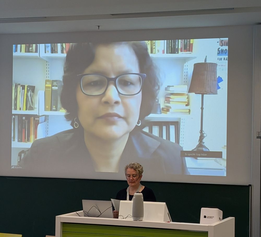 Ellen Grünkemeier in front of the video screen of keynote speaker Nivedita Majumdar 