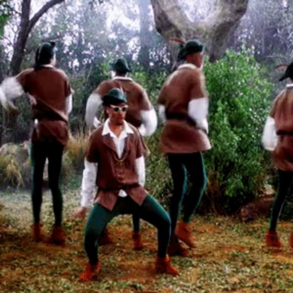 a group of men dressed in robin hood costumes are dancing in the grass