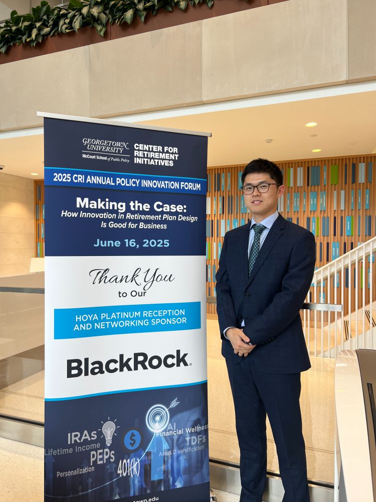 Person standing next to a banner at the Georgetown University McCourt School of Public Policy Center for Innovation Forum event titled "Making the Case: How CR Innovation in Retirement Plan Design is Good for Business." The banner also thanks sponsors including BlackRock.