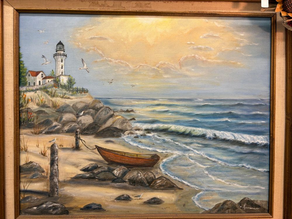 Small boat on beach near lighthouse.