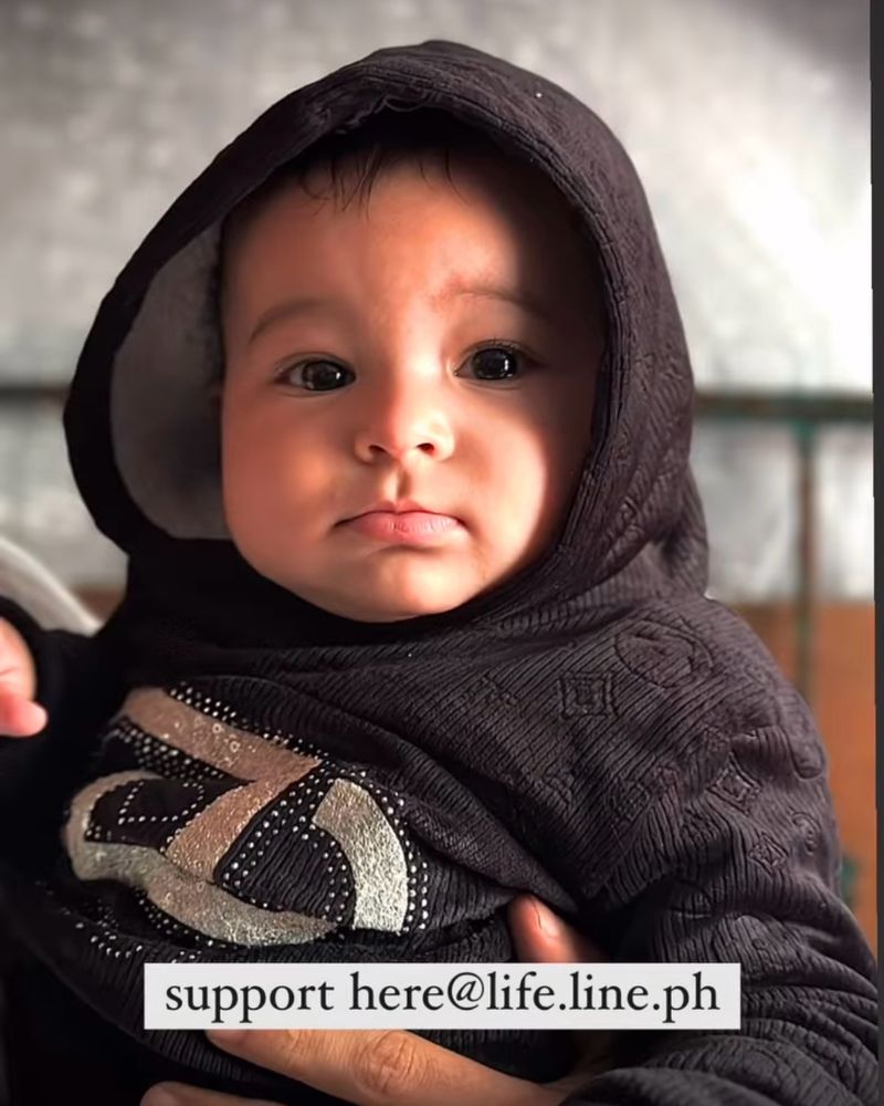 Baby being held in a Gaza pharmacy tent. 
